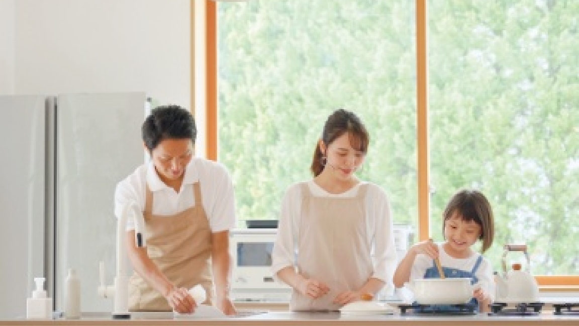 キッチンで料理をする３人家族