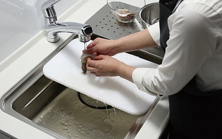 食材を洗って調理する写真